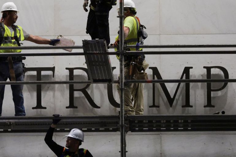 Workers stand on a building