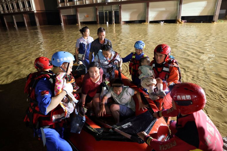Rescue workers evacuate residents in a rubber dinghy after floodwaters inundate villages downstream of the Liulan Reservoir dam breach [China Out/Reuters]