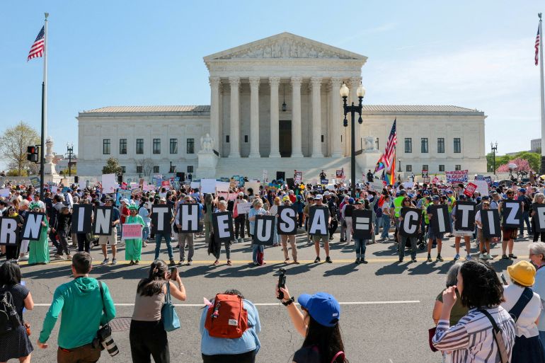 Demonstrators hold letters making up the slogan "Born in the USA = citizen!" outside the U.S. Supreme Court building