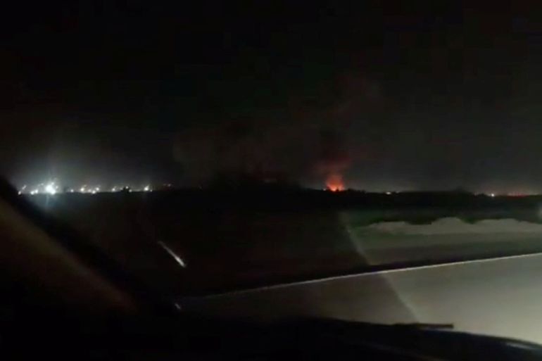 Fire and smoke rise from the direction of Iranshahr airport, as seen from the windscreen of a car, following a strike, near Iranshahr, Iran, in this screengrab from a social media video. Social Media/via REUTERS THIS IMAGE HAS BEEN SUPPLIED BY A THIRD PARTY. NO RESALES. NO ARCHIVES. VERIFICATION: - Road, barriers, drainage ditch and vegetation matched satellite imagery - Coordinates: 27.238113888619836, 60.70817332026714 - Date not verified - However, Iran’s semi-official Mehr News Agency reported attack on the city's airport facilities, citing local official - No older version of the footage was found posted online before July 9