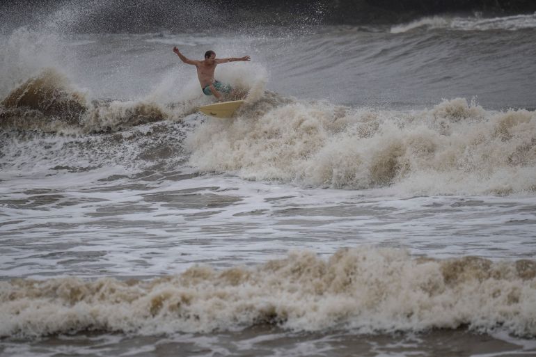 A surfer rides a high wave due to the effects of Super Typhoon Bavi in Guam on July 5, 2026.