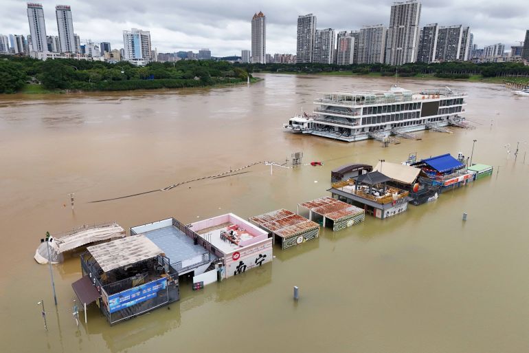 Flooded shops along a submerged riverside walk are seen by the overflowing Yongjiang river in Nanning, in China’s southern Guangxi region on July 7, 2026.