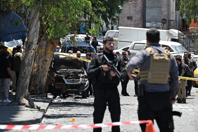 Security personnel stand guard near the Four Seasons Hotel following two blasts nearby in Damascus on July 7, 2026. Two explosions shook Damascus on July 7 near a hotel where French President Emmanuel Macron was staying, wounding at least 18 people, during the French leader's landmark visit to Syria. (Photo by LOUAI BESHARA / AFP)