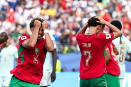 Morocco's midfielder #24 Neil El Aynaoui reacts to a missed chance along with other Morocco players.