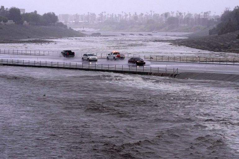 Vehicles cross over a flood control basin.