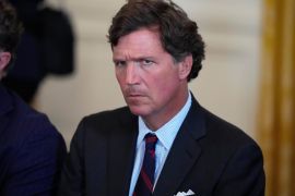 FILE - Tucker Carlson attends a meeting with President Donald Trump and oil executives in the East Room of the White House, Friday, Jan. 9, 2026, in Washington. (AP Photo/Alex Brandon)
