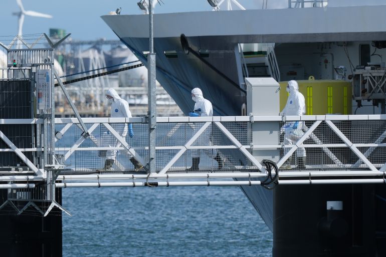 People in protective gear carry items as they disembark the MV Hondius cruise ship after its arrival at the Port of Rotterdam, Netherlands, Monday, May 18, 2026. (AP Photo/Patrick Post)