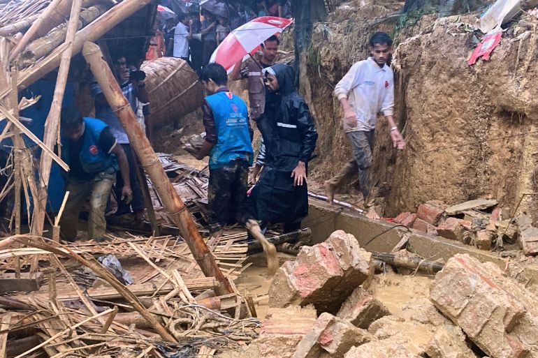 Rescuers work at the site of a landslide at a Rohingya refugee camp in Cox's Bazar, Bangladesh, Wednesday, July 8, 2026. (AP Photo/Shamimul Islam Faisal)