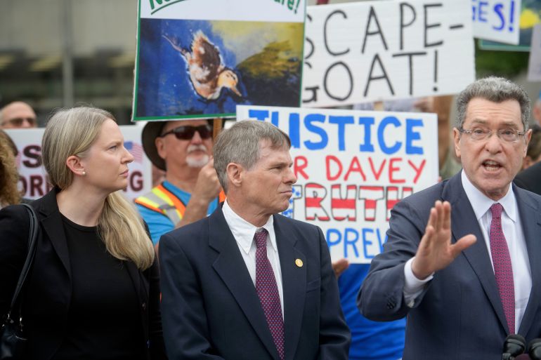 Former Olympic canoeist David Hearn, second from left, listens as his attorney Norman Eisen, right, speaks after he pleaded not guilty to allegedly damaging the Lincoln Memorial Reflecting Pool, Thursday, July 9, 2026, in Washington. (AP Photo/Rod Lamkey, Jr.)