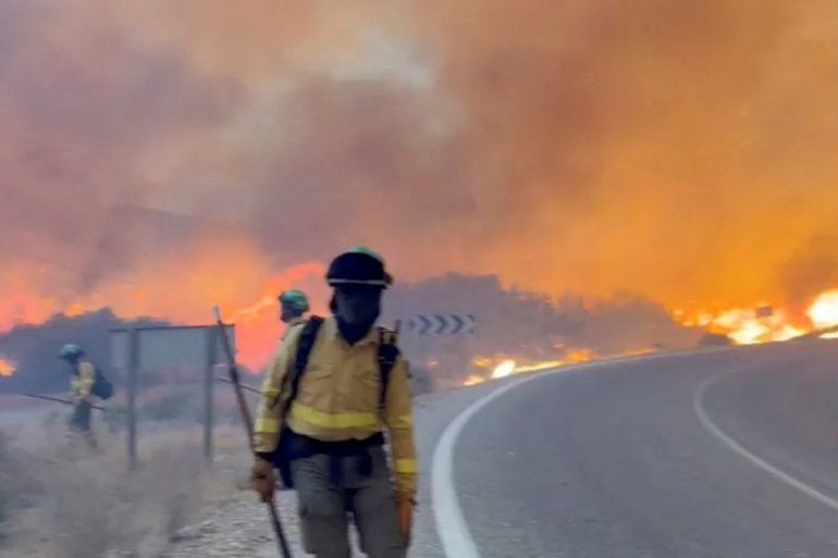 firefighter in front of blazing fire in spain